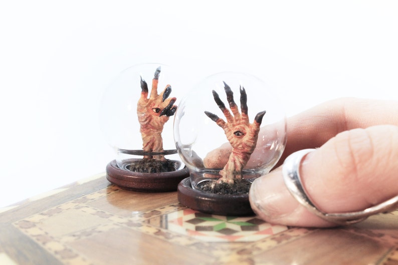 Pan's Labyrinth Pale Man Hands Miniature under a tiny glass dome, held by a hand, El Laberinto Del Fauno taxidermy Diorama by Guillermo Del Toro by modelmaker Stefanie Bonte