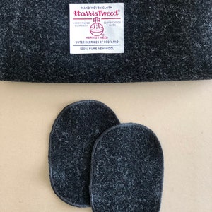 Puede incluir: Tela de lana Harris Tweed gris oscuro con dos parches ovalados. La tela tiene una textura tejida y una etiqueta blanca con el texto "Harris Tweed Outer Hebrides of Scotland 100% Pure New Wool."