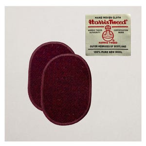 May include: Two oval burgundy Harris Tweed patches made from textured wool fabric. A rectangular label in the top right corner displays the Harris Tweed logo and text. The label states "Hand Woven Cloth".