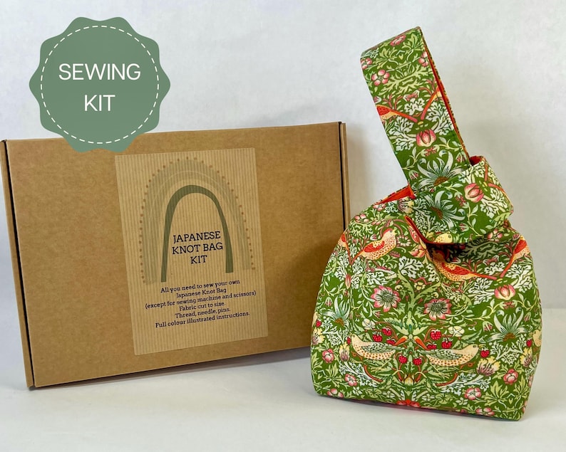 Image shows a sewing kit to make a Japanese Knot Bag with the box in the background and 
a readymade bag in Strawberry Thief fabric is on the right to demonstrate the finished product