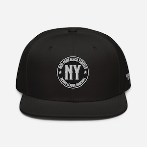 Puede incluir: Gorra de béisbol negra con un logotipo bordado en blanco que dice "New York Black Yankees Negro League Baseball" con una estrella a cada lado de la "NY" en el centro.
