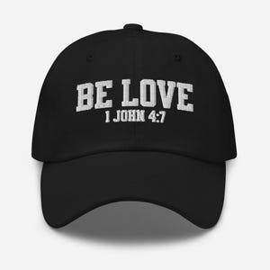 May include: Black baseball cap with white embroidered text that reads "BE LOVE 1 JOHN 4:7".