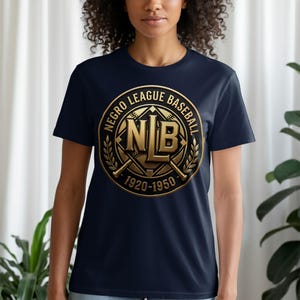 Puede incluir: Camiseta azul marino con un emblema dorado. El emblema dice "NEGRO LEAGUE BASEBALL" y "NLB 1920-1950". El diseño incluye bates de béisbol cruzados y una corona de laurel. Cuello redondo.