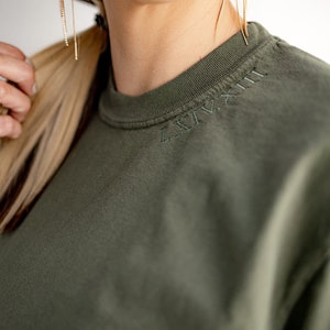 Camiseta con cuello bordado, números romanos y fecha de aniversario, colores cómodos. Personalizada. Teñida en prenda. Cuello redondo bordado.