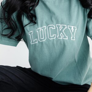 Camiseta de manga curta bordada Comfort Colors LUCKY - Camiseta com letras maiúsculas do time do colégio - Camiseta do Dia de São Patrício - Camiseta verde - Camiseta personalizada