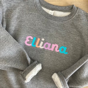 Sudadera con cuello redondo y nombre multicolor personalizada para niños pequeños - Personalizada - Suéter unisex - Monograma con nombre para niños y niñas - Arcoíris