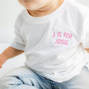 Camiseta de algodón orgánico con letras personalizadas bordadas con nombre para bebé - Ropa personalizada para bebé - Nombre con círculo curvo en el pecho izquierdo