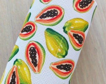 May include: White textured fabric roll featuring a repeating pattern of sliced papayas. The papayas are depicted in shades of green, yellow, orange, and red, with black seeds. The fabric has a slight sheen.