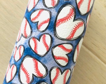 May include: A white fabric with a blue background and a pattern of red and white baseballs shaped into hearts.