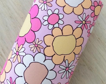 May include: Pink fabric with a repeating pattern of white, yellow, and pink flowers. The flowers are stylised and have a retro look.