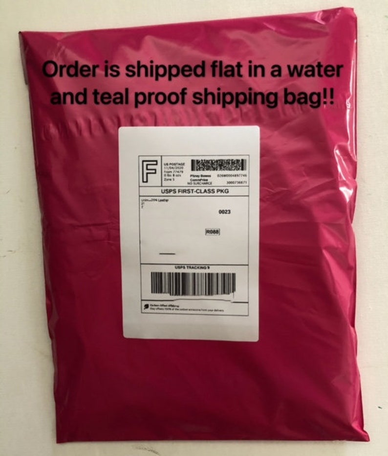May include: A pink plastic shipping bag with the text "Order is shipped flat in a water and teal proof shipping bag!!" printed on the front. The bag has a white label with the text "USPS FIRST-CLASS PKG" and a tracking number.