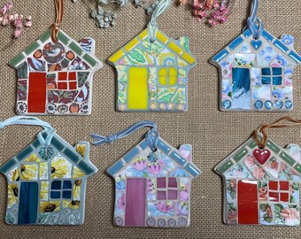 May include: Six handmade mosaic house ornaments with different designs. Each house is made of colorful tiles and has a unique pattern. The houses are all about 4 inches tall and are perfect for hanging on a Christmas tree or as a decorative accent.