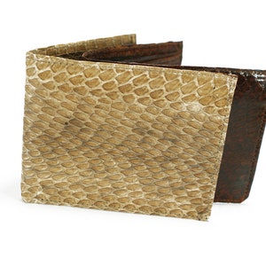 Peut inclure: Un portefeuille pliable présentant un motif texturé en peau de serpent beige clair sur le panneau avant extérieur. Les sections intérieure et arrière du portefeuille sont fabriquées dans un matériau lisse marron foncé contrastant avec un léger éclat.