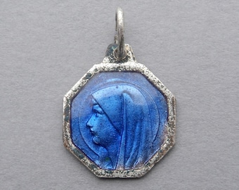 May include: A silver octagonal pendant with a blue enamel image of the Virgin Mary. The pendant has a loop at the top for hanging.