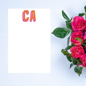 May include: A white card with the letters "CA" in orange and pink with a drop shadow. A bouquet of pink roses with green leaves is in the bottom right corner of the image.