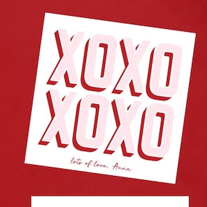 May include: Two white cards with the text "XOXO" printed in pink with a shadow effect. The cards have different messages at the bottom. The first card says "lots of love, Anna" and the second card says "your friend, Lucy". The cards are surrounded by pink paper hearts on a red background.