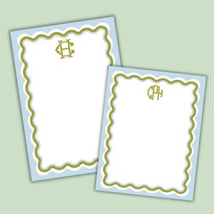 May include: Two personalized stationery sheets. The sheets have a white interior, a light blue border, and a scalloped edge with a gold trim. One sheet has the initials "HC" and the other has the initials "CPB" in a gold color.