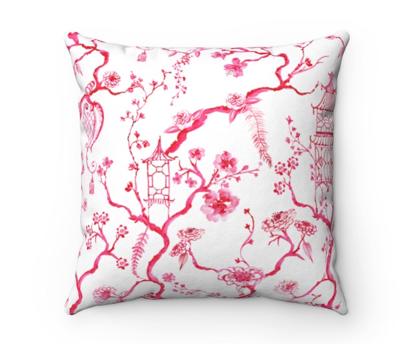 May include: Pink and white throw pillow with a floral pattern featuring a repeating design of branches, flowers, and pagodas.
