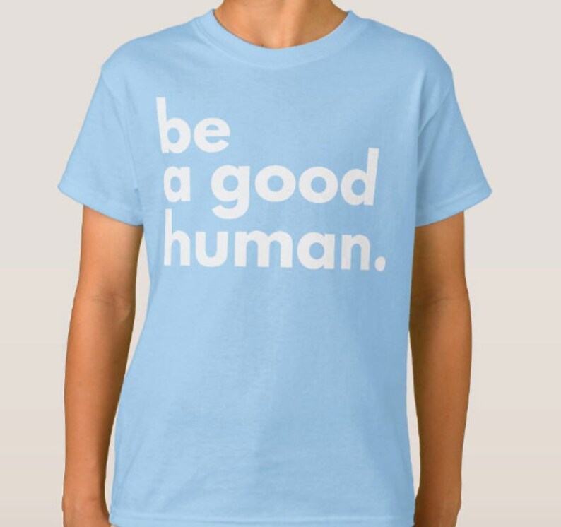 May include: Light blue t-shirt with the text "be a good human." printed in white.