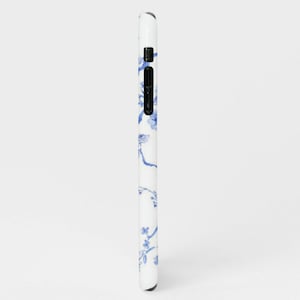 May include: A white phone case with a blue floral pattern. The pattern features delicate branches with small blue flowers.