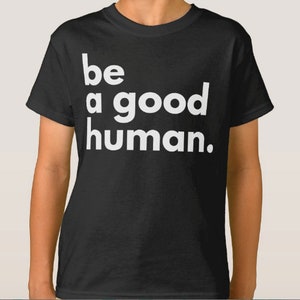 May include: Black t-shirt with white text that reads "be a good human."