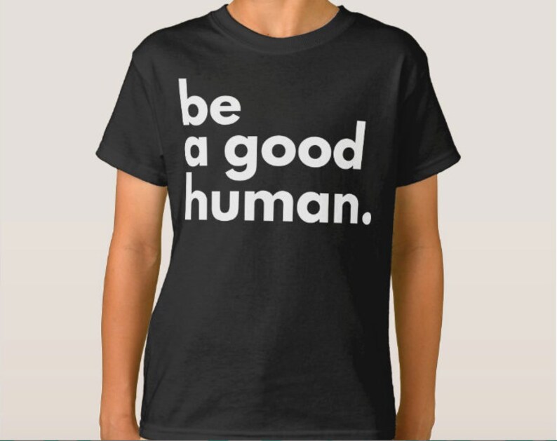 May include: Black t-shirt with white text that reads "be a good human."