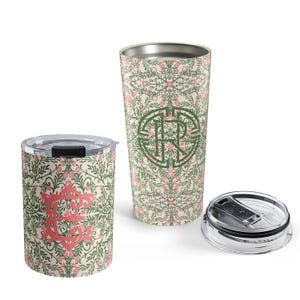 May include: A short tumbler with a pink letter E and a tall tumbler with a green monogram, both featuring a cream background with a repeating green vine and pink floral pattern. Each tumbler includes a clear plastic lid with a black sliding closure.