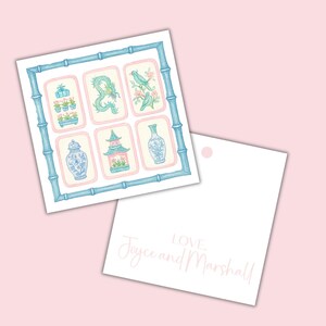 May include: A square card with a bamboo-style border in light blue surrounds six rectangular illustrations. The illustrations feature a dragon, birds, a vase, a pagoda, and other decorative elements in shades of blue and pink. A second card has the text "Love, Joyce and Marshall."