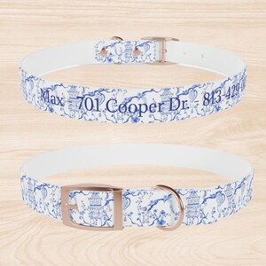 Op de afbeelding: Witte hondenriem met een blauw en wit bloemenpatroon en ros&eacute;gouden beslag. De riem heeft de tekst "Max - 701 Cooper Dr - 813-429-0000" erop gedrukt.