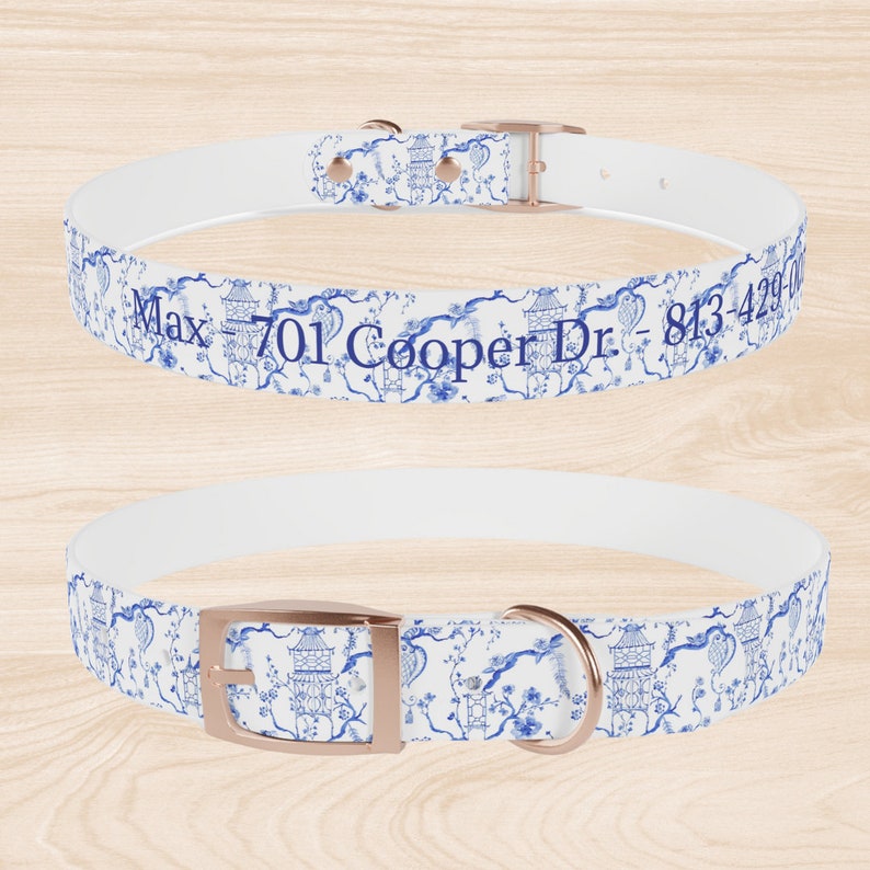 Op de afbeelding: Witte hondenriem met een blauw en wit bloemenpatroon en ros&eacute;gouden beslag. De riem heeft de tekst "Max - 701 Cooper Dr - 813-429-0000" erop gedrukt.