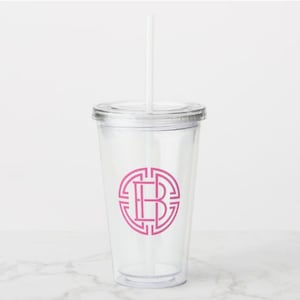 May include: A clear plastic tumbler with a pink monogram "B" inside a geometric circle design. The tumbler has a lid and a straw.