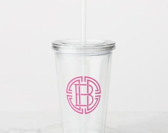 May include: A clear plastic tumbler with a pink monogram "B" inside a geometric circle design. The tumbler has a lid and a straw.