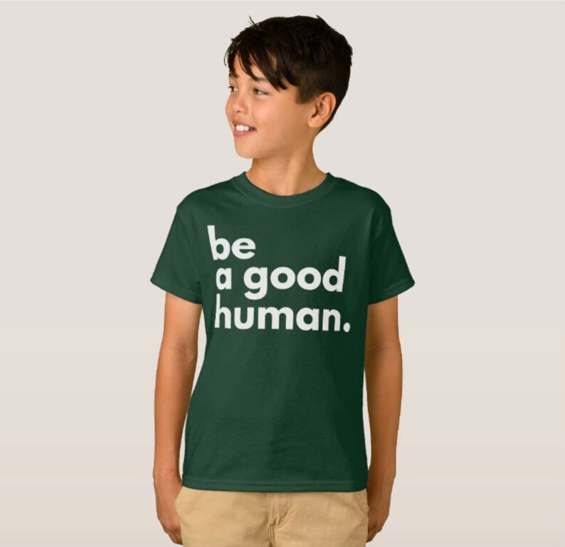 May include: A dark green t-shirt with white text that reads "be a good human."