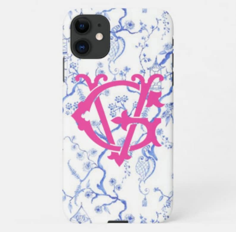 May include: A white iPhone case with a blue and white floral pattern and a pink monogram "VF" in the center.
