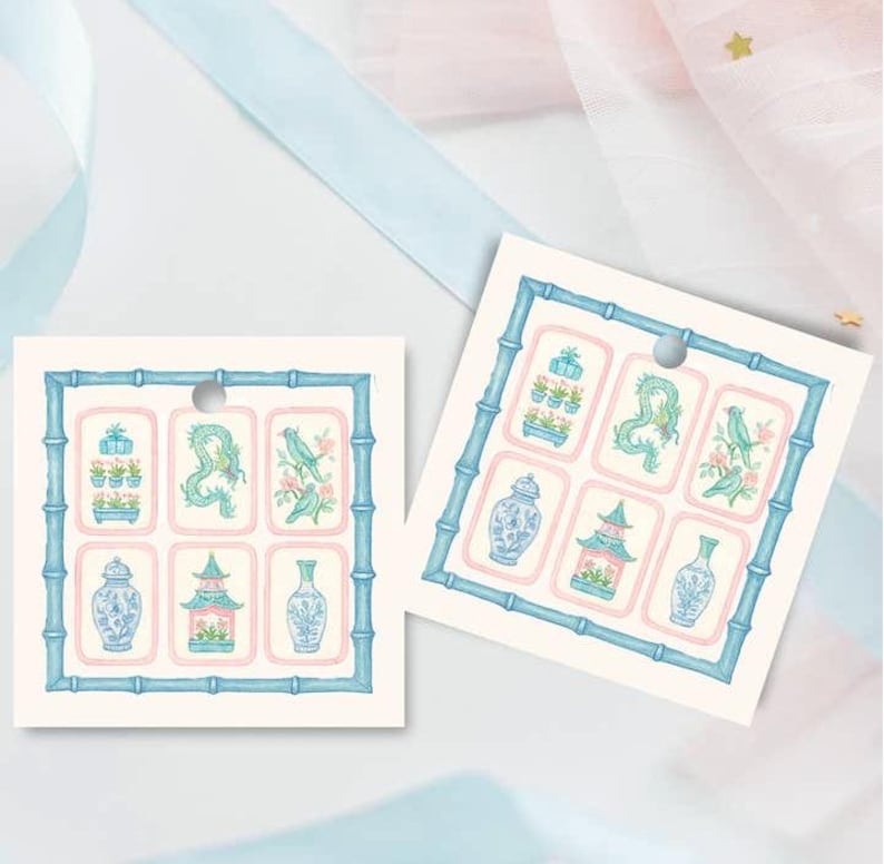 May include: Two square gift tags with a bamboo-style border in blue. Each tag features six illustrations of vases, pagodas, and birds in a soft color palette of blue, pink, and green. A small hole is at the top for hanging.