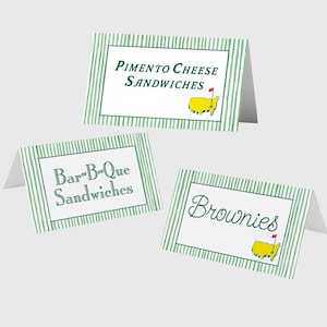 May include: Three white tent cards with green striped borders and text. The top card reads "Pimento Cheese Sandwiches" with a yellow map graphic. The second card says "Bar-B-Que Sandwiches". The third card says "Brownies" with a yellow map graphic.