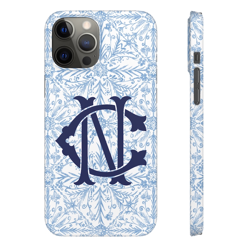 May include: A white phone case with a blue and white floral pattern and a navy blue monogram "NC" in the centre.