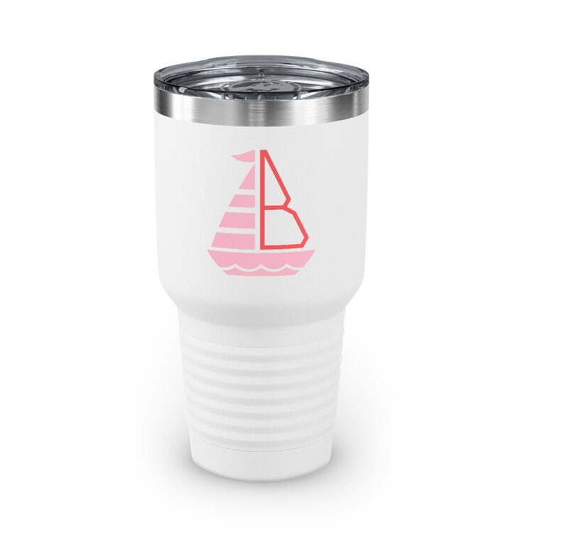 K&ouml;nnte beinhalten: Ein wei&szlig;er Edelstahlbecher mit einer rosa Segelbootgrafik und dem Buchstaben "B" in Rot. Der Becher hat ein geripptes Design.