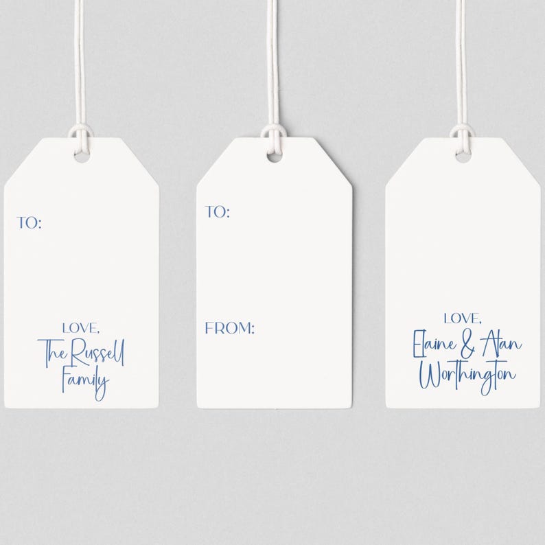 May include: Three white gift tags with a string attached. Each tag has the word "TO:" printed at the top. The first tag says "LOVE, The Russell Family". The second tag says "FROM:". The third tag says "LOVE, Elaine & Alan Worthington".