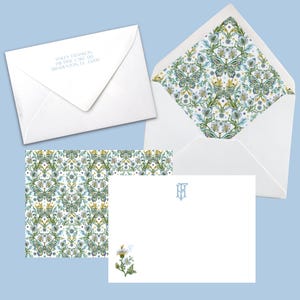 May include: White stationery set featuring a patterned envelope liner with butterflies, flowers, and foliage in green, blue, and yellow. Includes a matching patterned card, a blank card with a floral illustration, and an envelope with printed address.