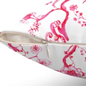 May include: White pillow cover with a pink floral pattern. The pillow cover has a zipper closure.