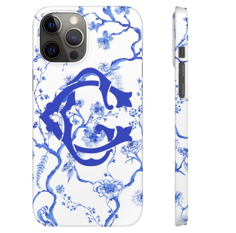 May include: A white phone case with a blue and white floral pattern and a blue monogram in the center.