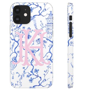 May include: A white phone case with a blue and white floral pattern and a pink monogram "KA".