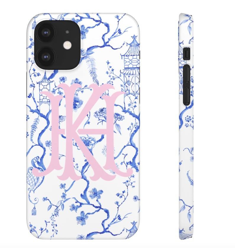 May include: A white phone case with a blue and white floral pattern and a pink monogram "KA".
