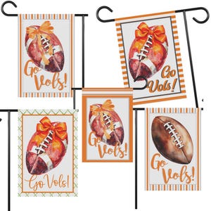 Puede incluir: Un conjunto de cinco banderas decorativas para jard&iacute;n con dise&ntilde;os de f&uacute;tbol en acuarela. Cada bandera muestra un bal&oacute;n de f&uacute;tbol con un lazo naranja y el texto "Go Vols!". Las banderas tienen bordes naranjas y blancos.