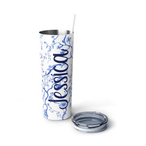 May include: A white stainless steel tumbler with a blue and white floral pattern and the name "Jessica" printed on the side. The tumbler has a lid and a straw.