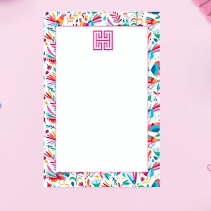 May include: White notepad with a pink border and a pink monogram "HH" in the centre. The border is decorated with a colourful Mexican folk art pattern featuring flowers, birds, and geometric shapes.