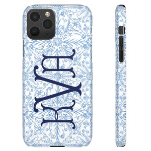 May include: A white phone case with a blue and white floral pattern and the monogram "KAY" in navy blue.