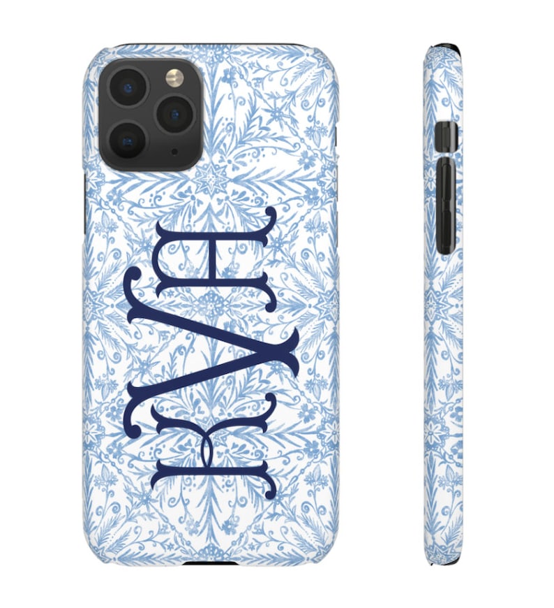 May include: A white phone case with a blue and white floral pattern and the monogram "KAY" in navy blue.