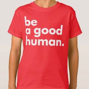 May include: Red t-shirt with white text that reads "be a good human."